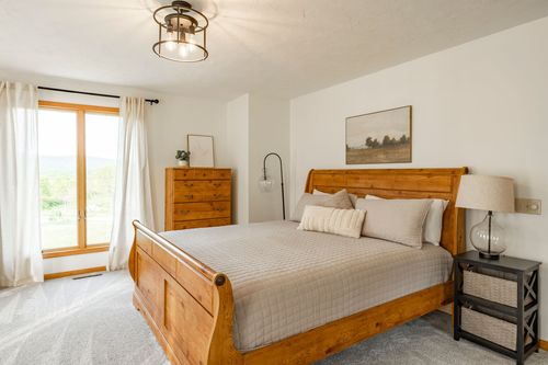 Primary bedroom with a wood sleigh bed and a window overlooking mountain views