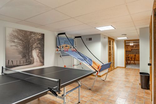 Basement game room with a ping pong table and an arcade basketball hoop game