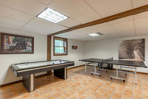 Recreation room with an air hockey table and ping pong table on tile flooring