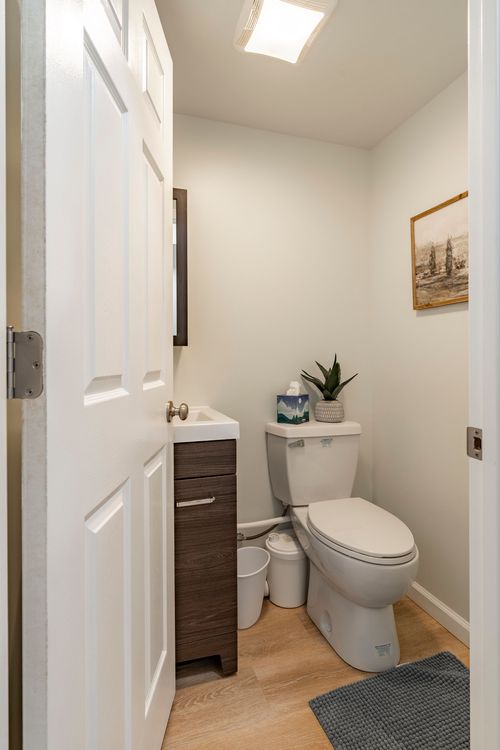 Powder room with a dark wood vanity, gray towels and framed artwork