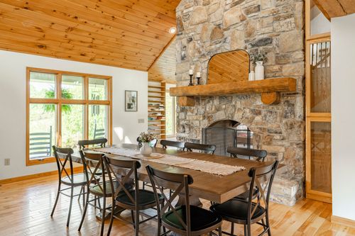 Dining nook with a stone fireplace and vaulted wood ceiling