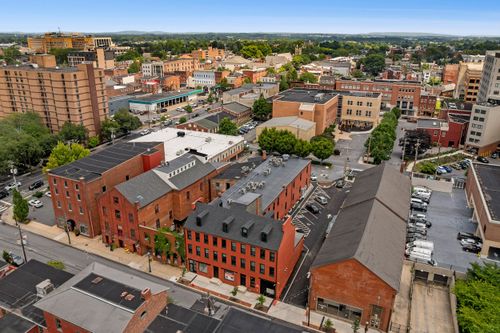 Aerial view of downtown rooftops with a restored brick apartment building and city skyline beyond