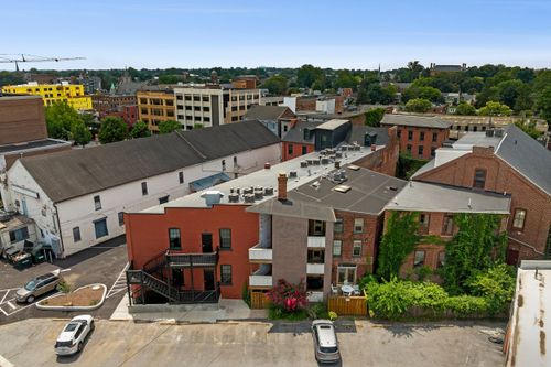 Aerial view of red brick rowhouses and rooftops with a construction crane on the skyline