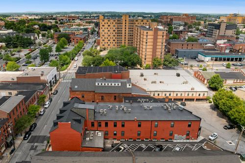 Aerial view of a downtown streetscape with a brick apartment building near a high-rise tower