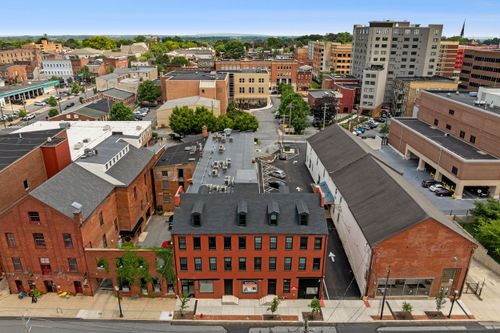 Aerial view of a city plaza surrounded by brick buildings and high-rise towers