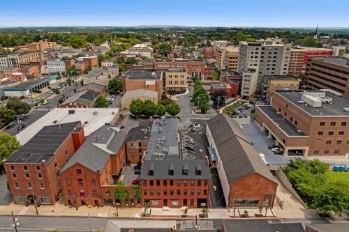 Aerial view of a historic downtown district with brick rowhouses, church spires and city towers
