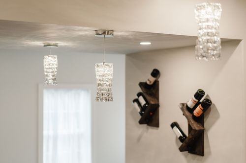 Bar area with crystal pendant lights, a wall-mounted wine rack and a curtained window