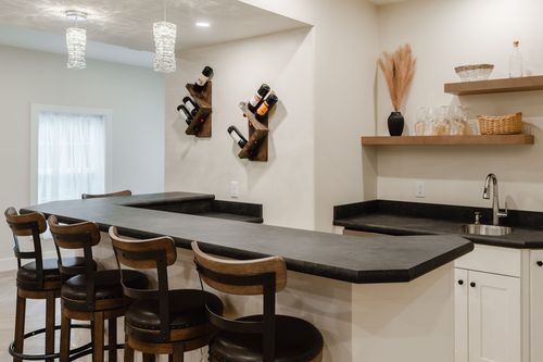 Basement bar with a rustic wood wine rack, floating shelves and leather barstools