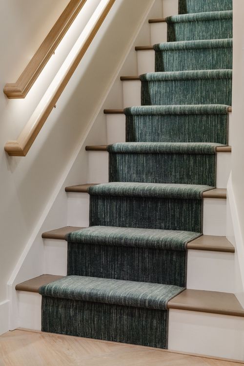 Carpeted stair treads with a teal herringbone-pattern runner and brown wood risers