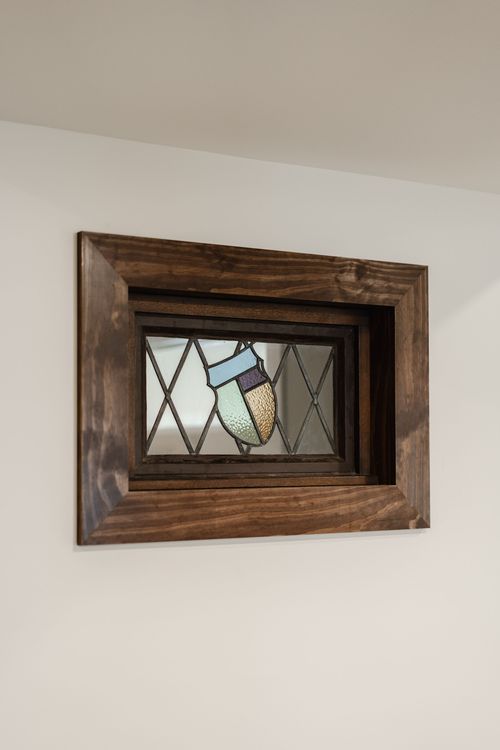 Close-up of a framed stained glass panel with a diamond lattice border