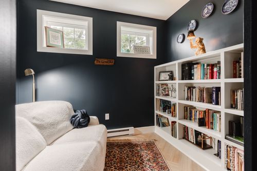 Reading nook with a boucle sofa and a white built-in bookcase full of books