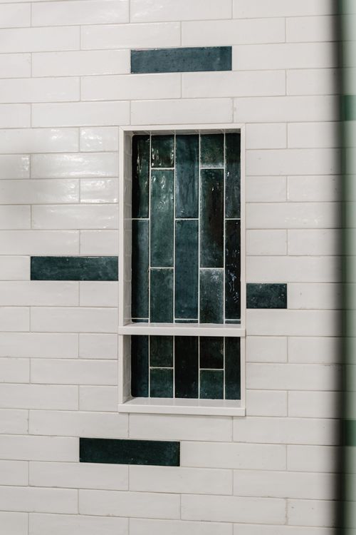Extreme close-up of a dark green tiled shower niche