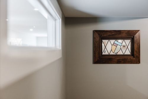 Stained glass window detail with an ice cream cone motif in a wood frame