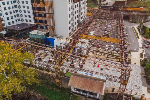 Aerial view of a hotel construction site with a steel trestle frame beside a river