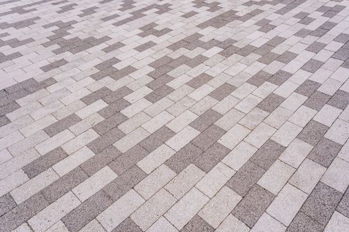 Close-up of a gray and tan basket-weave paver pattern
