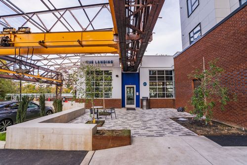 Restaurant entrance with a blue door, patio seating and flower planters