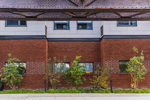 Brick and metal panel building exterior with young ornamental trees