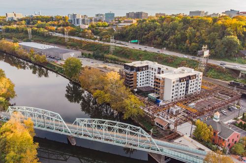Aerial view of a hotel and rooftop terrace under construction next to a river