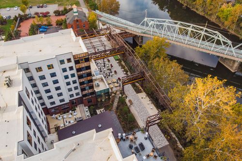 Aerial view of a paver courtyard beneath a restored steel trestle beside a hotel