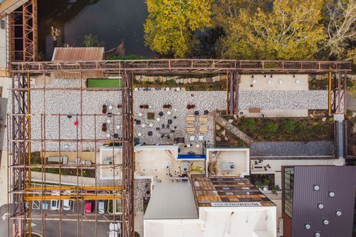 Aerial view of a gray and tan geometric paver courtyard with steel trestle framework