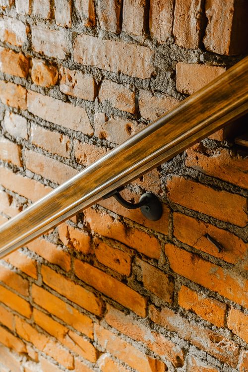 Close-up of a small bronze rabbit figurine set into an exposed brick niche