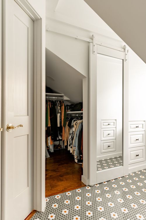 Closet doorway with a paneled door and mirrored sliding barn door beside a walk-in closet