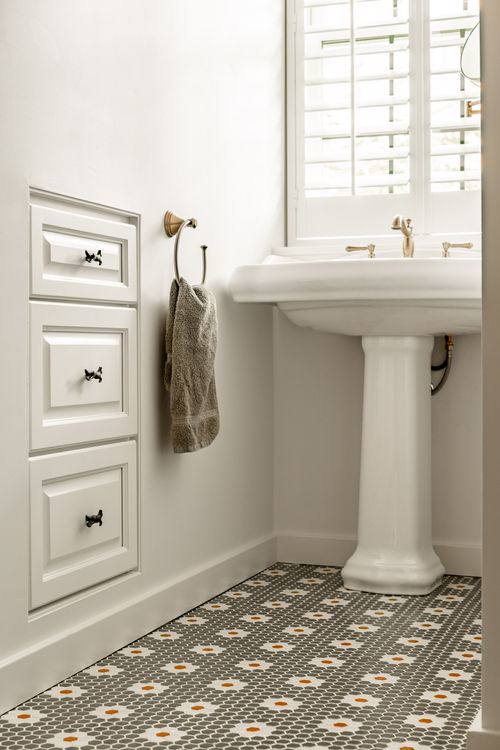 White built-in drawers with whimsical brass animal pulls and a towel ring