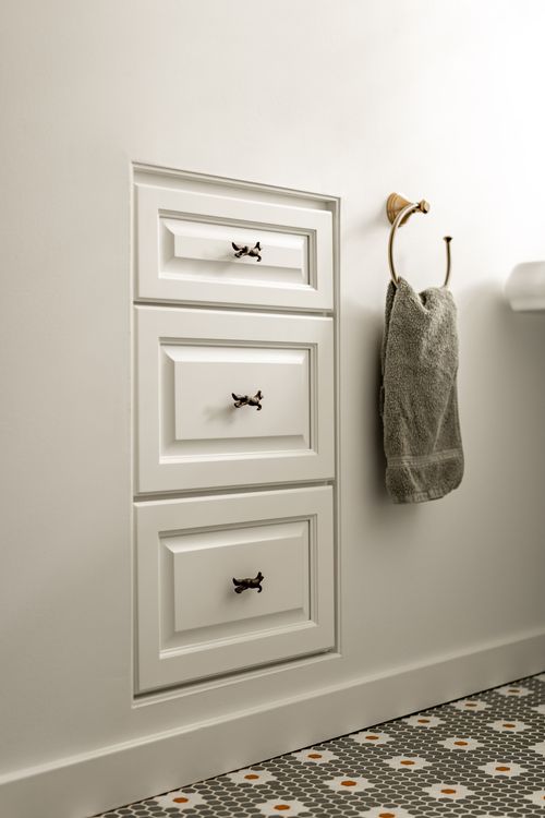 Pedestal sink with a gooseneck faucet beside a drawer stack and hexagon tile floor