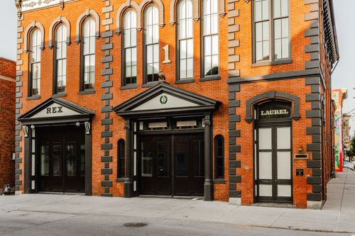 Street-level view of the REX and Laurel entrances along a renovated brick storefront