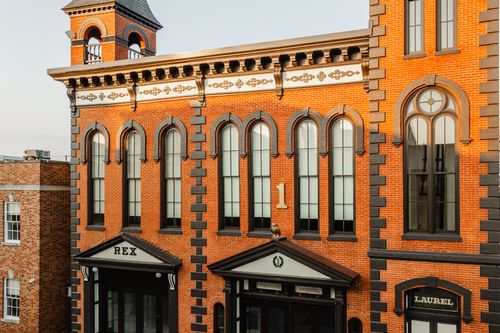 Elevated view of the ornate brick tower with arched windows and entrance signs below