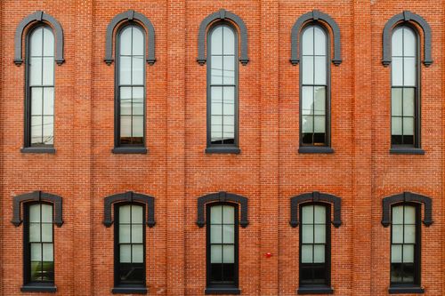 Grid of ten arched brick windows with matching black-painted surrounds