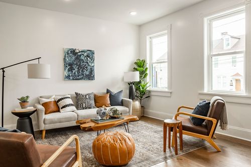 Bright living room with gray sofa, leather chairs and a large fiddle-leaf fig by the window
