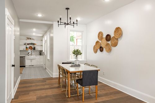 Dining room with a black sputnik chandelier, woven basket wall art and a farmhouse table