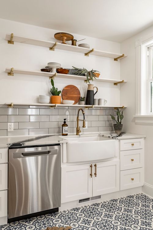 Open wood shelving, subway tile backsplash and a white farmhouse sink beside a dishwasher