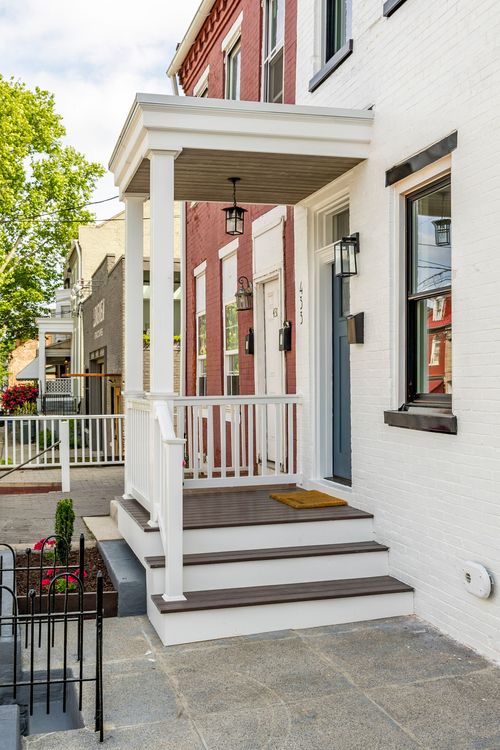 Covered porch with a wood-plank ceiling, hanging lantern and wood-plank front steps