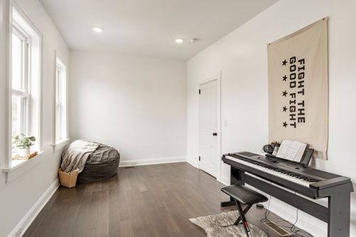 Bonus room with a beanbag chair, digital piano and a Fight the Good Fight wall banner