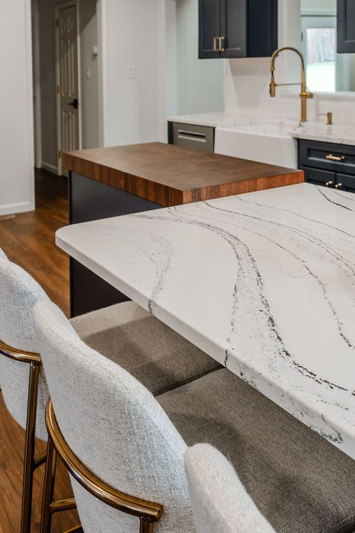 White quartz waterfall island edge with a hallway and dining area beyond