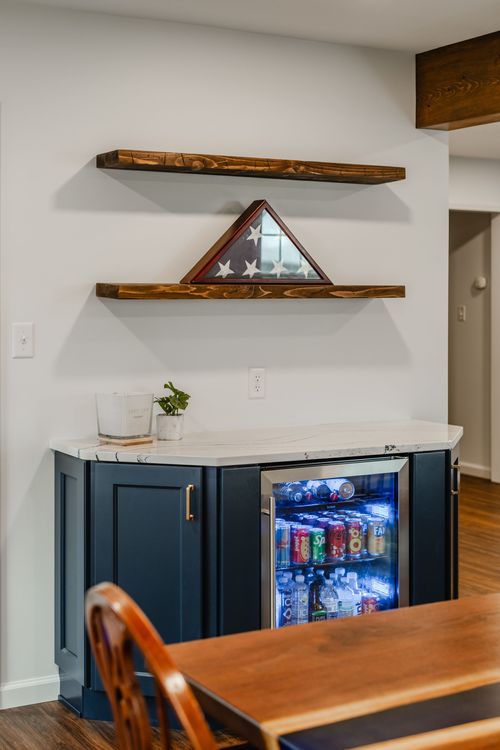 Corner beverage bar with folded flag display, windsor chair and wood beam ceiling