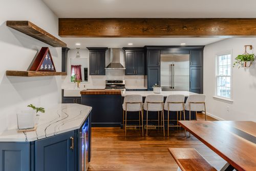 Gas range and stainless hood beside a walnut butcher-block island top