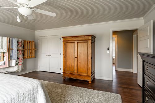 Bedroom with a pine armoire, quilt rack and beadboard ceiling