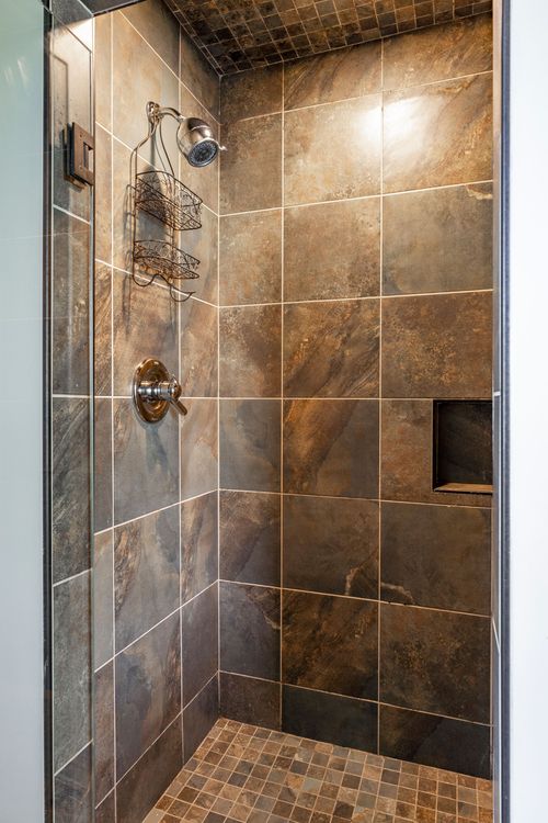 Close-up of a slate-tiled walk-in shower with a built-in niche
