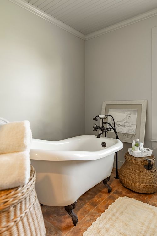 Bathroom with a clawfoot tub, oil-rubbed bronze fixtures and framed artwork