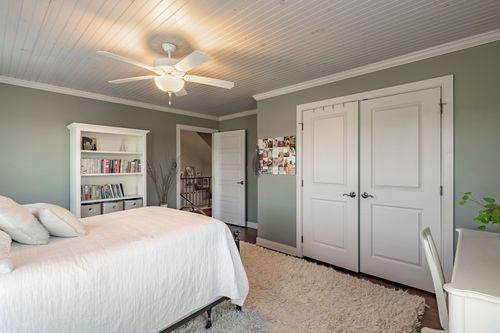 Bedroom with gray walls, a white bookshelf and closet doors