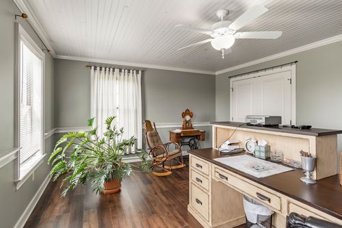 Office nook with an antique sewing table, built-in desk and potted plant