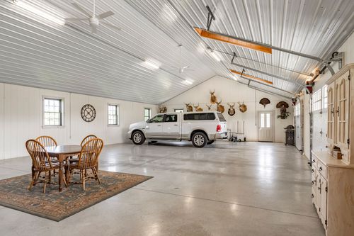 Pole barn interior with a parked pickup truck, taxidermy mounts and a dining table