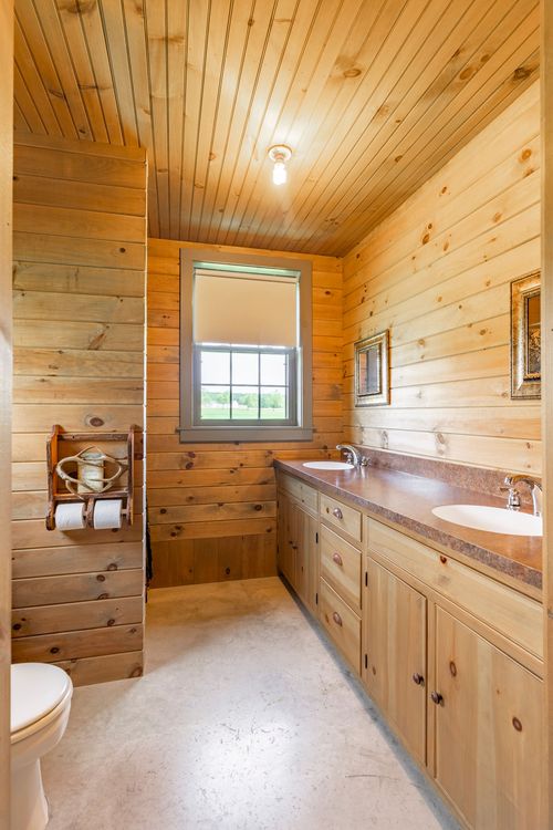 Knotty pine bathroom with a double vanity and wood beadboard ceiling