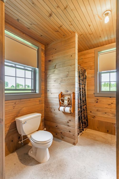 Knotty pine bathroom with a walk-in shower behind a camo curtain