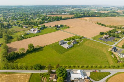 Aerial view of a farmhouse and outbuildings set within patchwork farmland
