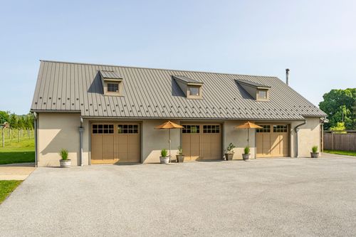 Four-car garage with wood carriage-style doors and dormer windows