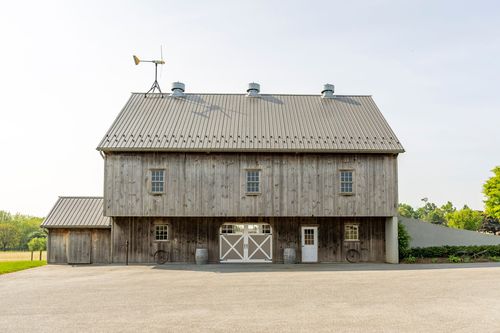 Weathered barn front with white sliding doors and small windows